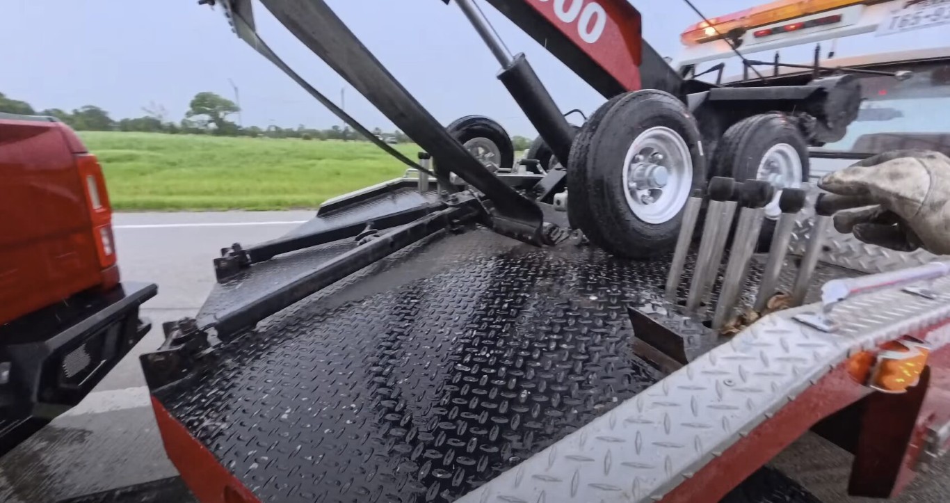 Heavy-duty tow truck winch equipment rigged and ready for vehicle extraction in wet conditions